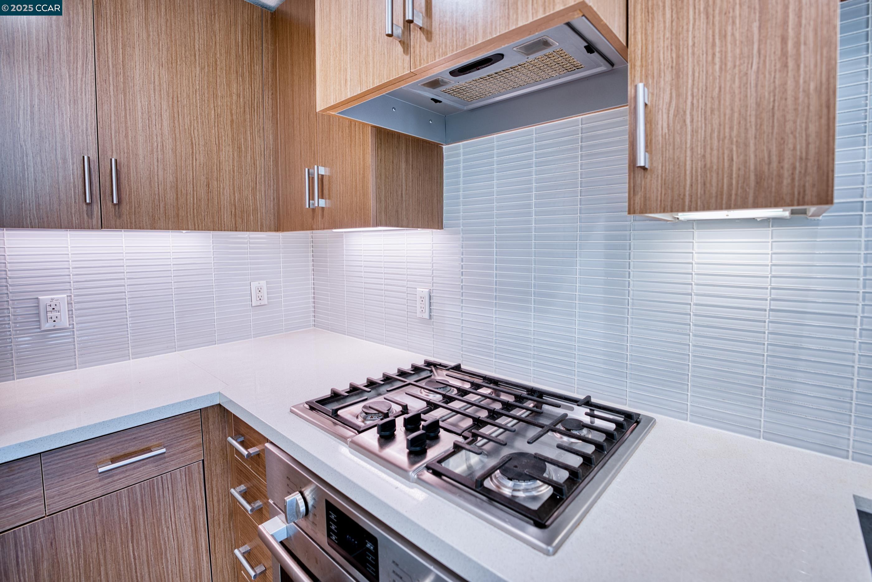 2655 Bush Street, Unit 110 San Francisco, CA 94115 - Photo 28 of 52 a kitchen with wooden cabinets and a stove top oven