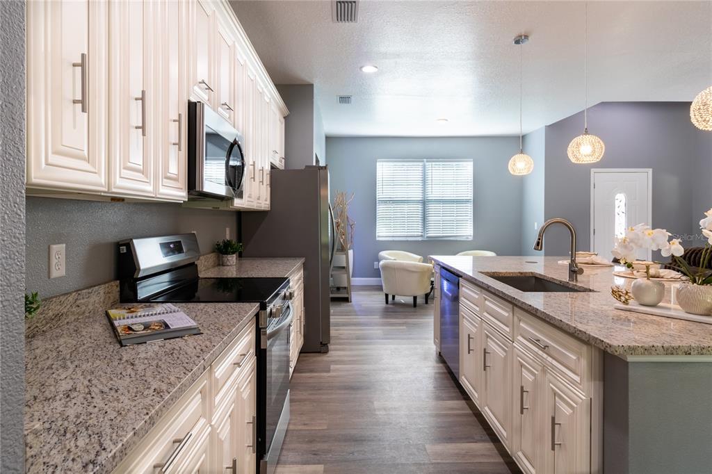 41550 Royal Trails Road Eustis, FL 32736 - Photo 5 of 25 a kitchen with stainless steel appliances granite countertop a sink stove and refrigerator