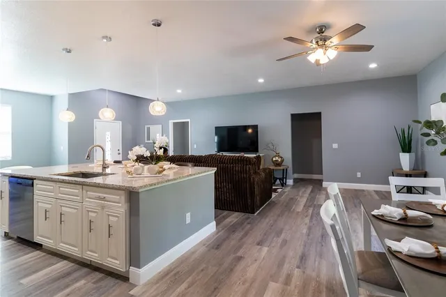 a view of a kitchen counter space a sink wooden floor and a view of living room