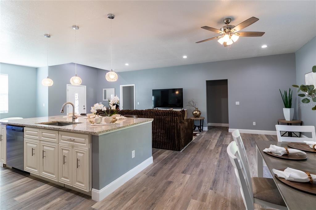 41550 Royal Trails Road Eustis, FL 32736 - Photo 6 of 25 a view of a kitchen counter space a sink wooden floor and a view of living room
