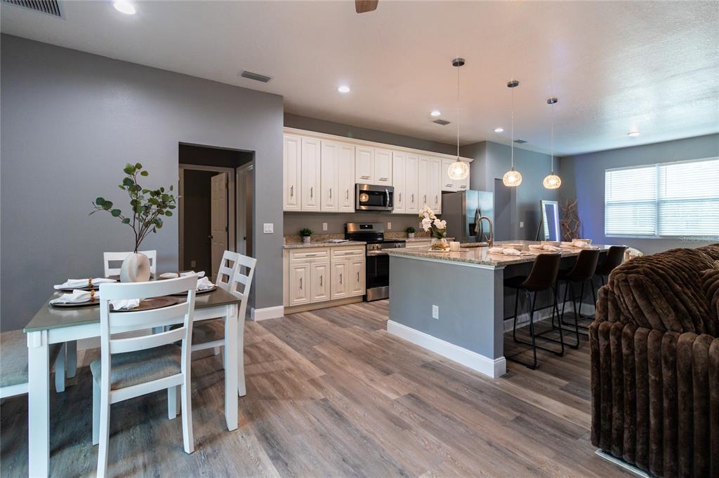 41550 Royal Trails Road Eustis, FL 32736 - Photo 7 of 25 a kitchen with stainless steel appliances kitchen island granite countertop a table chairs refrigerator and microwave