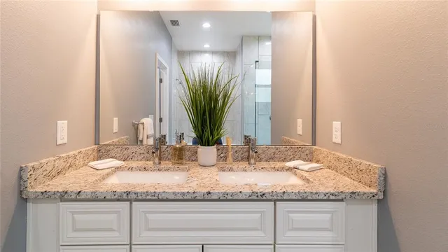 a bathroom with a granite countertop sink and a mirror