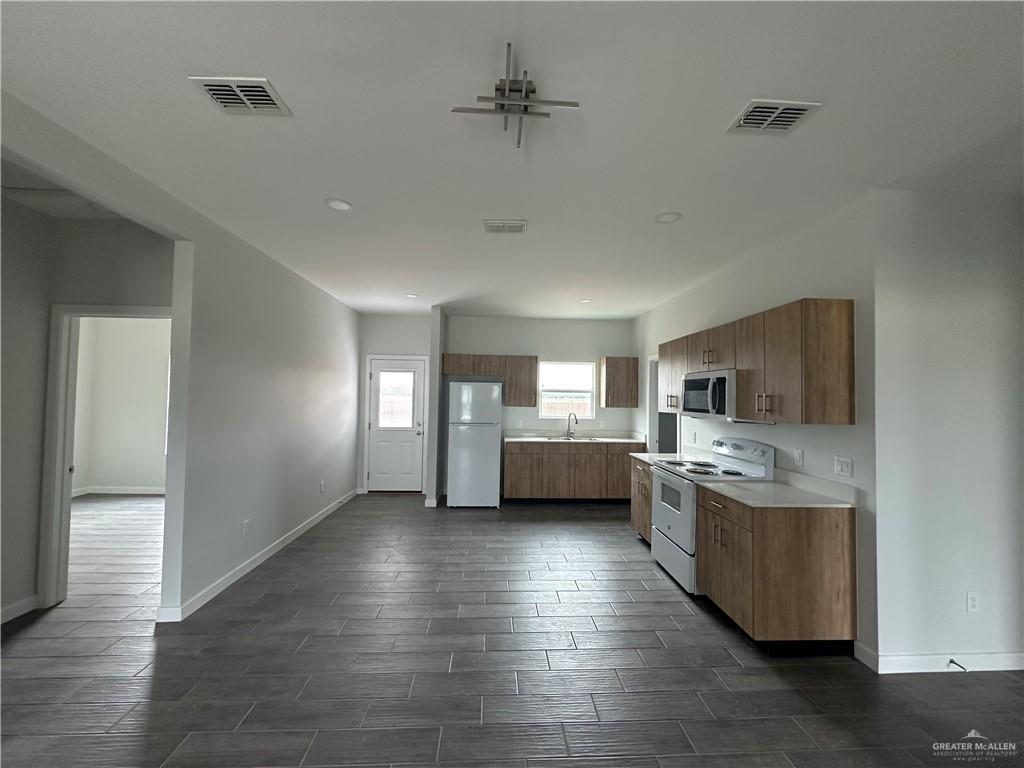 1708 Unity Drive Mercedes, TX 78570 - Photo 3 of 11 a view of kitchen and kitchen with a sink wooden floor and windows