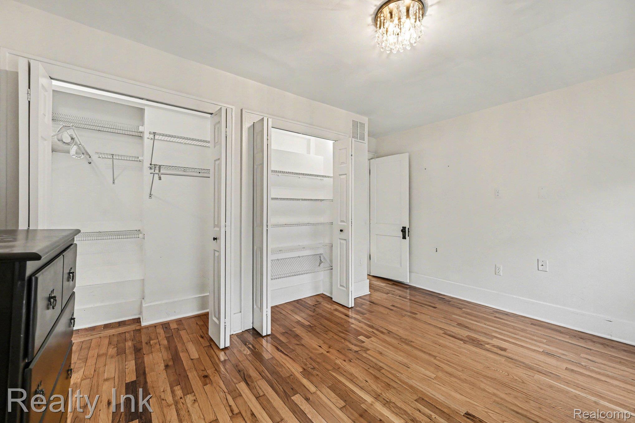 16944 Franklin Road Northville, MI 48168 - Photo 7 of 11 Unfurnished bedroom with light wood finished floors and multiple closets