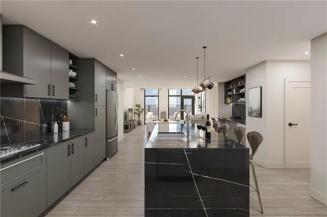 a dining hall with stainless steel appliances kitchen island granite countertop a refrigerator and cabinets