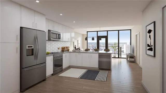a kitchen with a refrigerator a sink and white cabinets with wooden floor