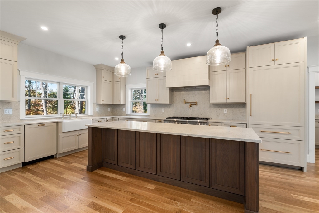 21 Quiet Street Sandwich, MA 02537 - Photo 7 of 15 a large kitchen with kitchen island white cabinets and wooden floor