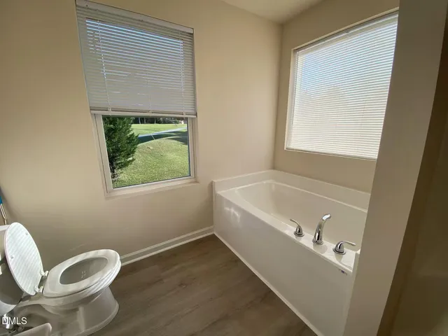 a bathroom with a bathtub and a window