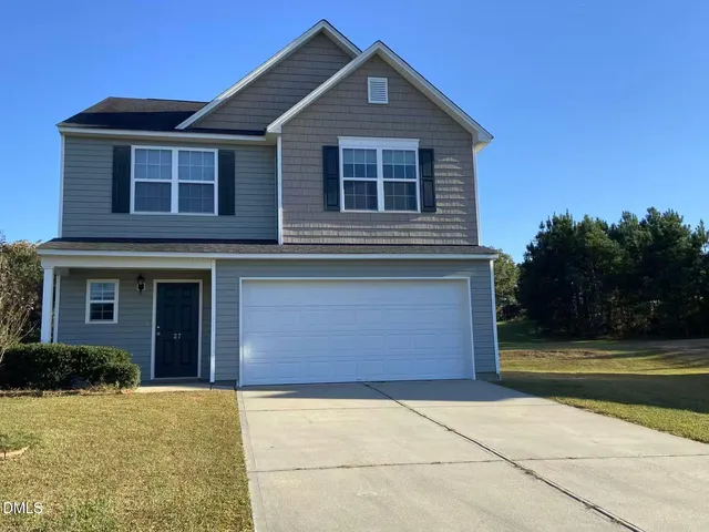 a front view of a house with a yard and garage