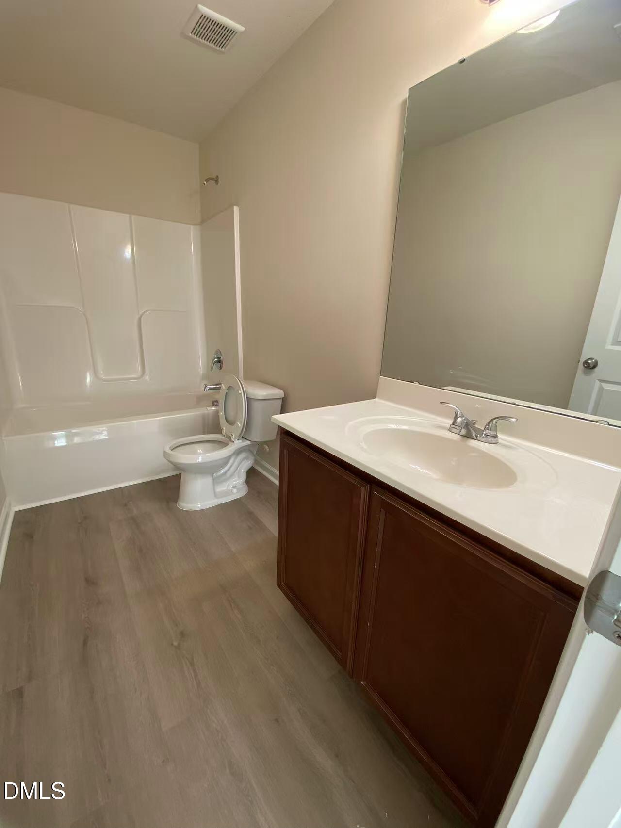 27 Ridgemoore Court Four Oaks, NC 27524 - Photo 22 of 24 a bathroom with a sink a toilet and a large mirror
