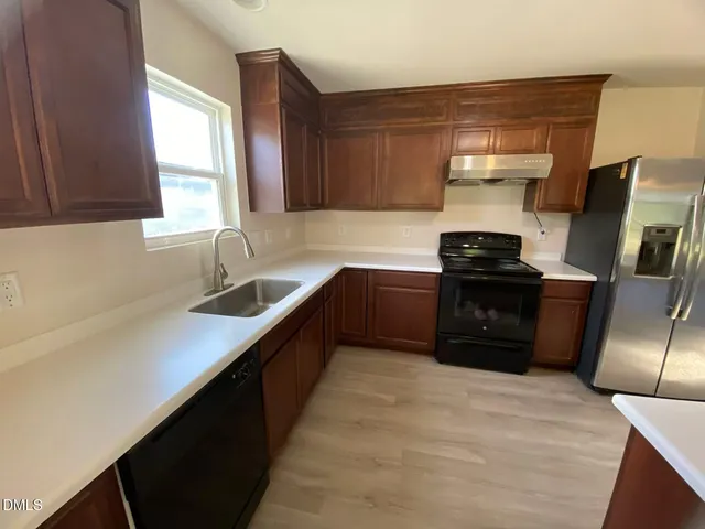 a kitchen with stainless steel appliances a sink stove and refrigerator