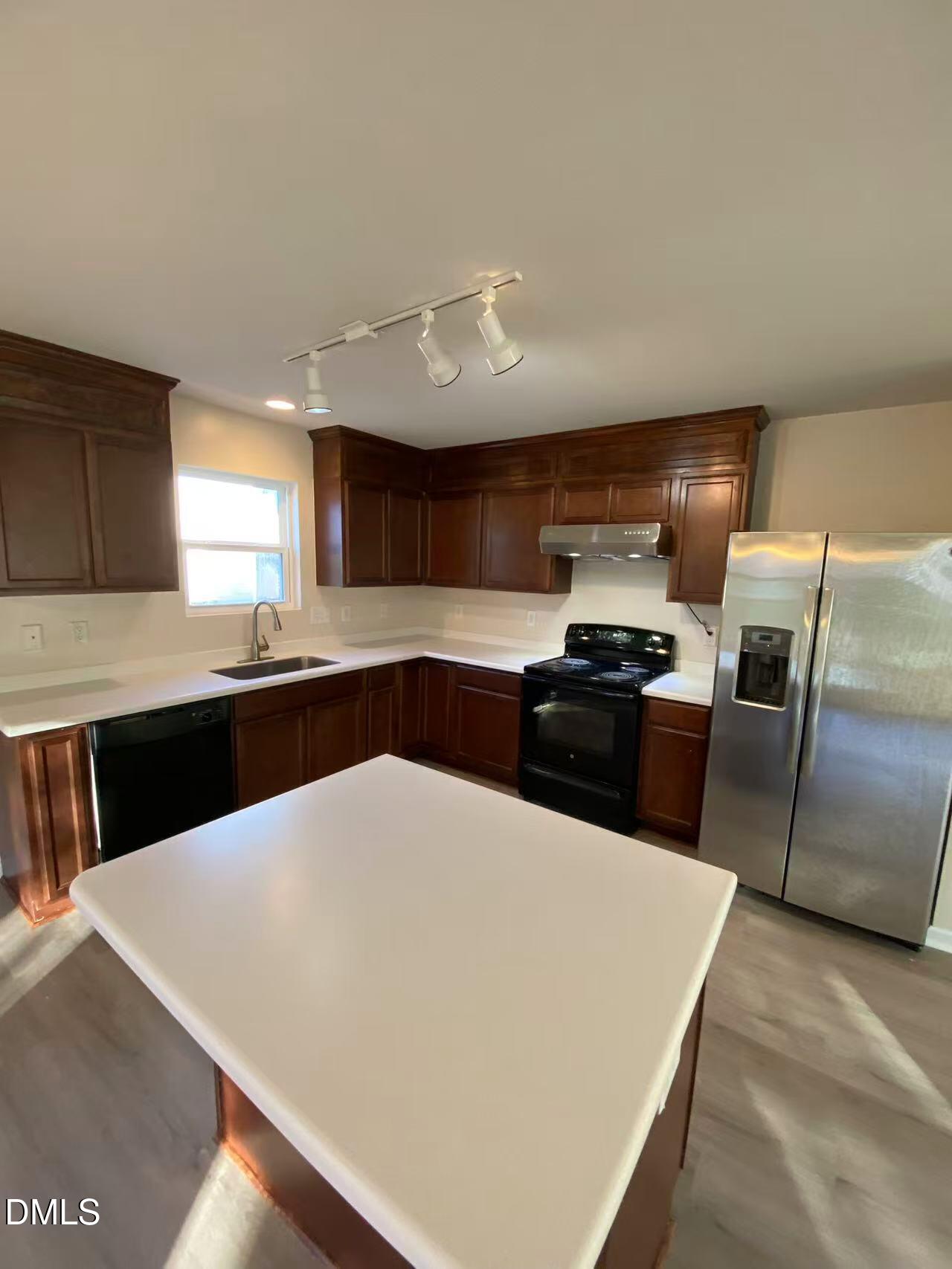 27 Ridgemoore Court Four Oaks, NC 27524 - Photo 6 of 24 a kitchen with granite countertop a sink a counter space stainless steel appliances and cabinets