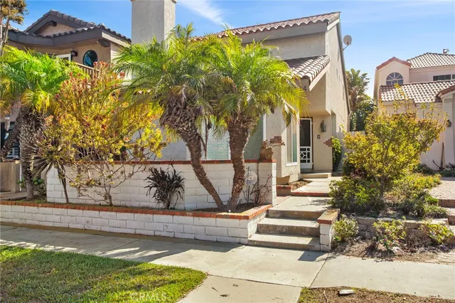 a front view of a house with a yard and potted plants