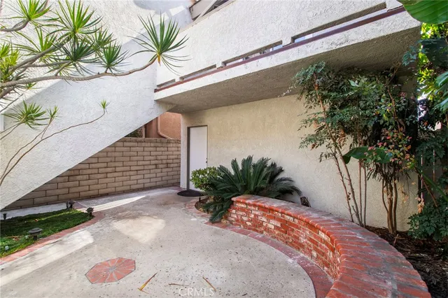 a view of a house with a yard and potted plants