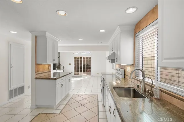 a kitchen with granite countertop a sink and a stove top oven