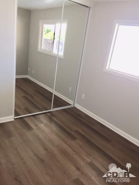 10394 Cochran Avenue Riverside, CA 92505 - Photo 11 of 12 an empty room with wooden floor and windows