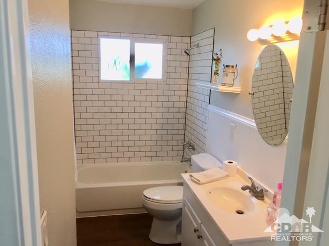 10394 Cochran Avenue Riverside, CA 92505 - Photo 9 of 12 a bathroom with a sink a toilet and shower curtain