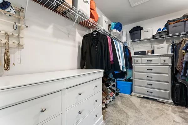 a view of walk in closet with clothes and shoes