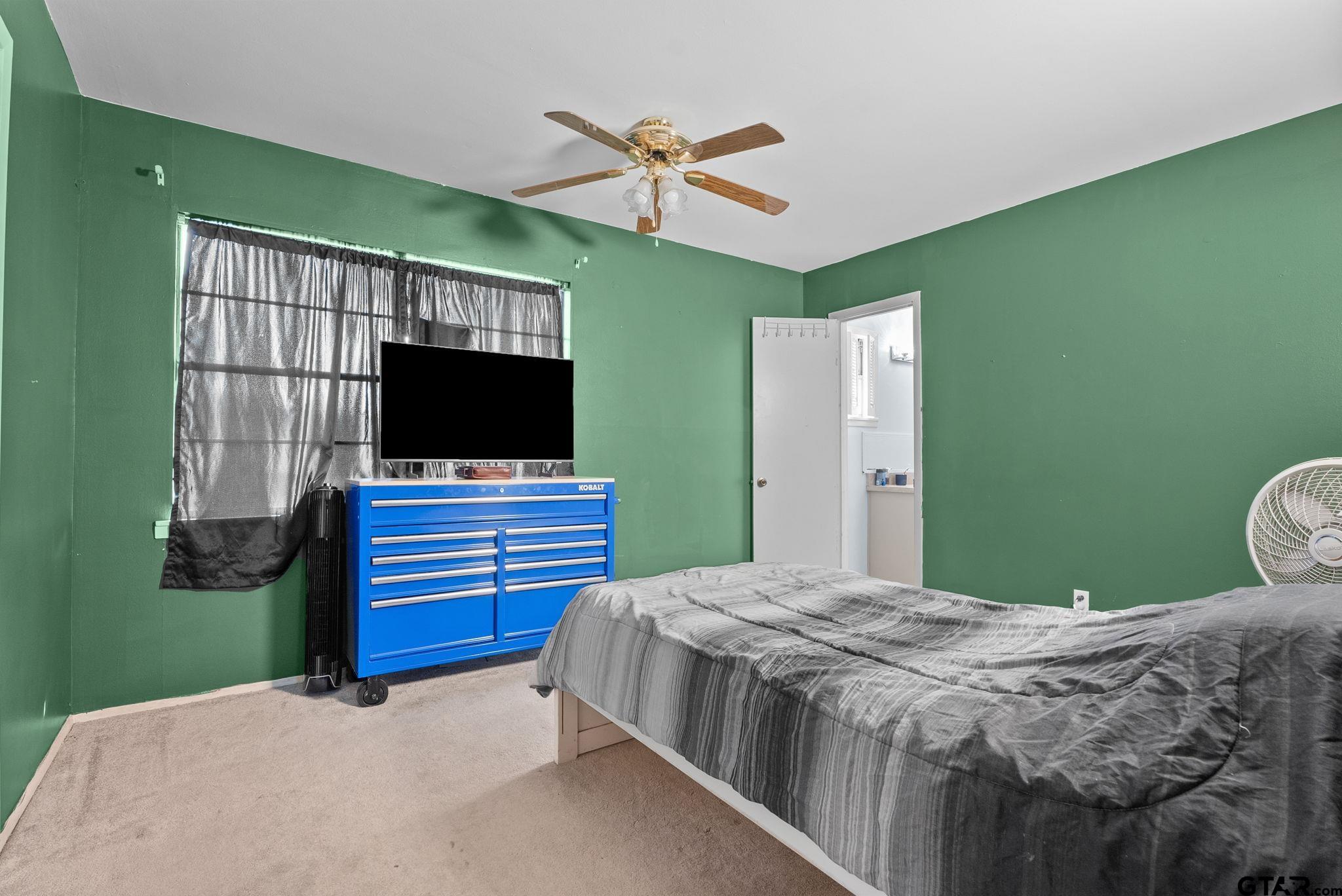 2002 Faulkner Street Tyler, TX 75701 - Photo 12 of 32 a bedroom with a bed and a flat screen tv