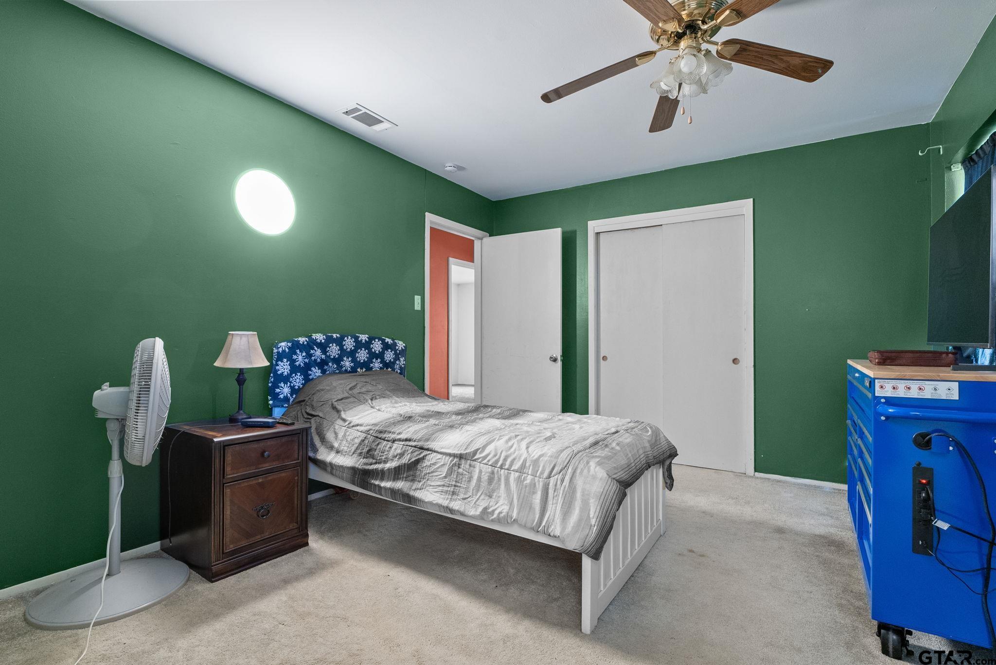 2002 Faulkner Street Tyler, TX 75701 - Photo 13 of 32 a bedroom with a bed and a chandelier