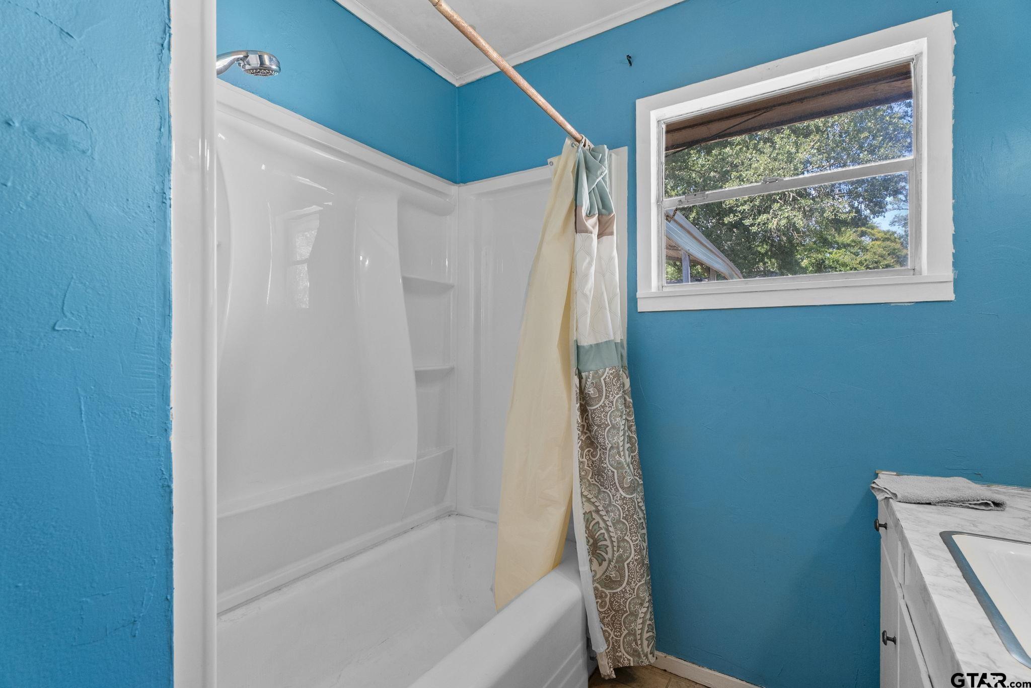 2002 Faulkner Street Tyler, TX 75701 - Photo 21 of 32 a bathroom with a bathtub and a shower