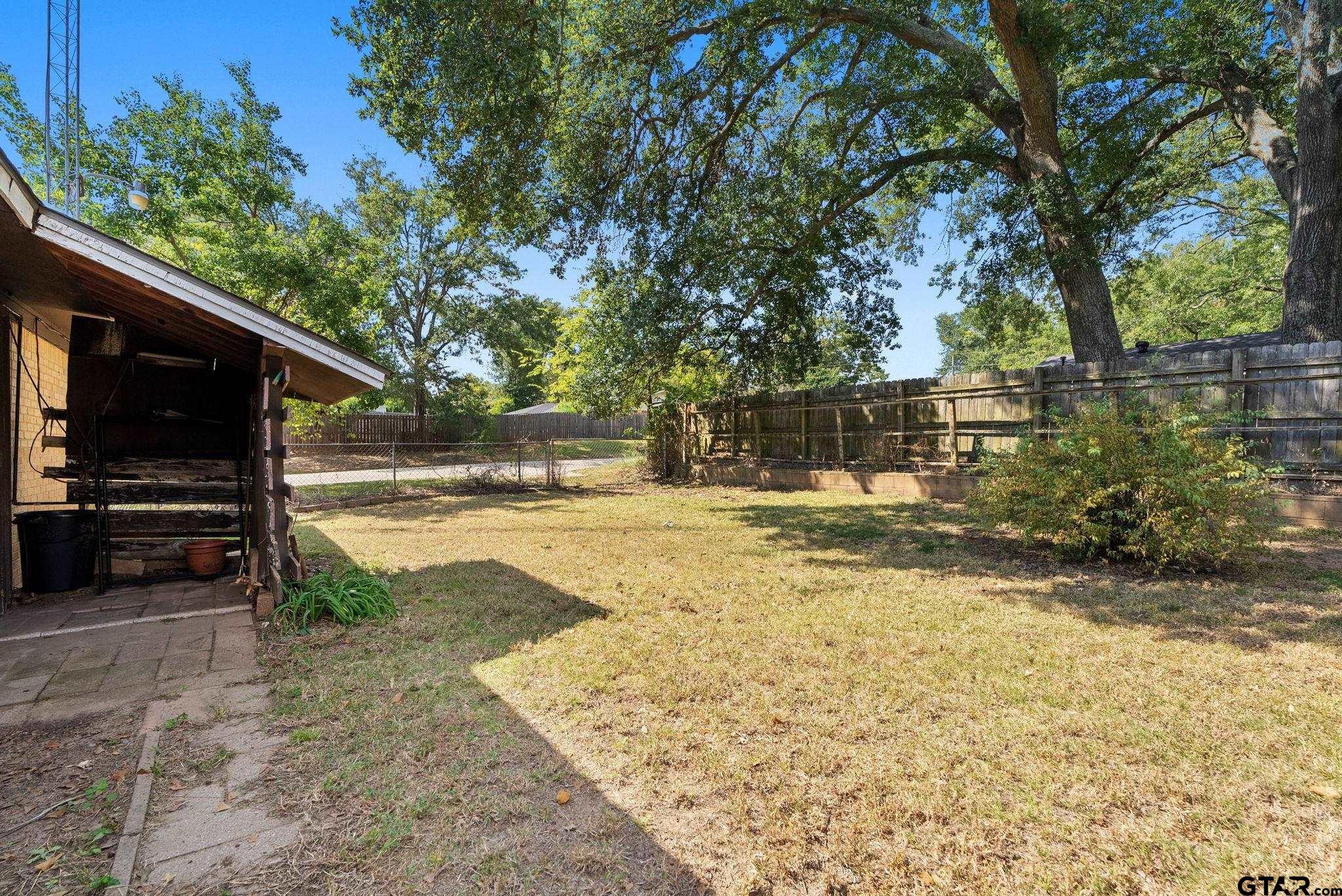 2002 Faulkner Street Tyler, TX 75701 - Photo 32 of 32 a view of yard with wooden fence and a large tree