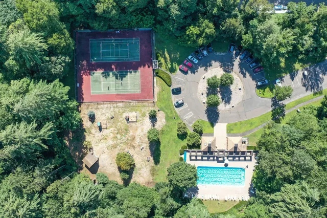 an aerial view of residential house with outdoor space and trees all around