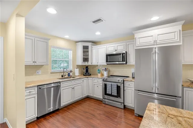 a kitchen with white cabinets and stainless steel appliances