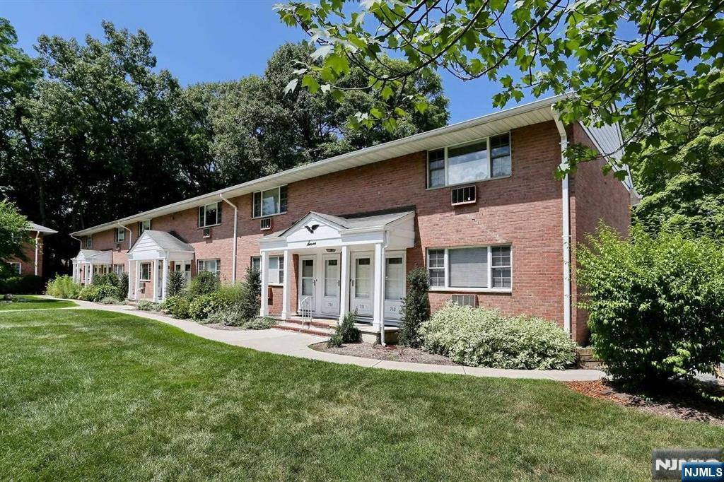 712 Washington Drive, Unit 712 Ramsey, NJ 07446 - Photo 1 of 20 a front view of a house with a yard table and chairs
