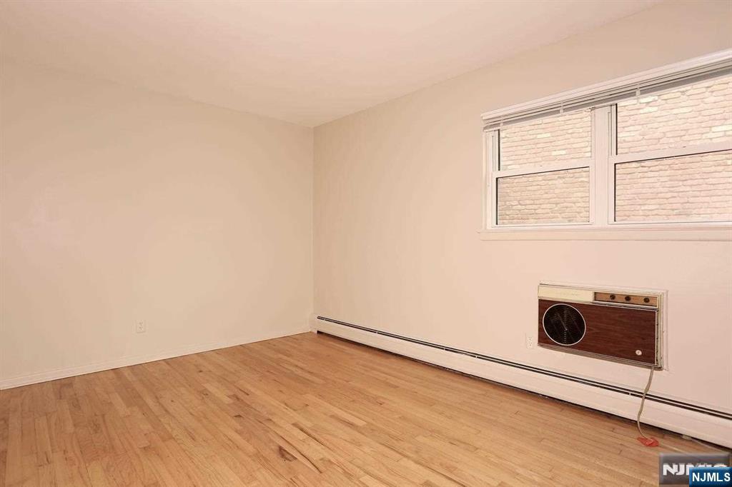 712 Washington Drive, Unit 712 Ramsey, NJ 07446 - Photo 12 of 20 a view of empty room with wooden floor and fan