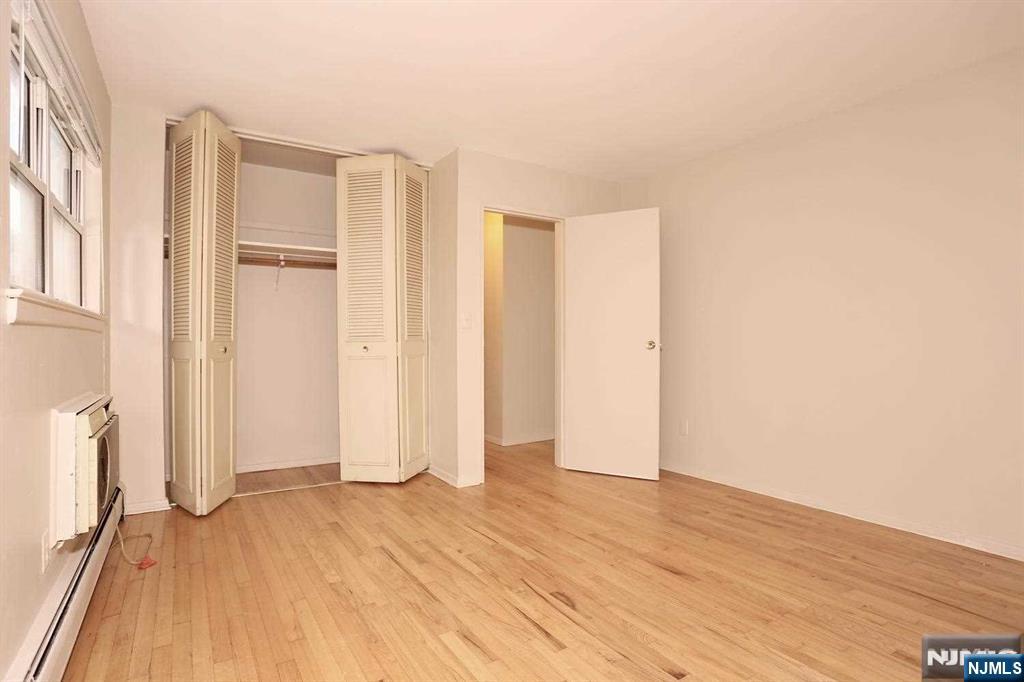 712 Washington Drive, Unit 712 Ramsey, NJ 07446 - Photo 14 of 20 an empty room with wooden floor and windows