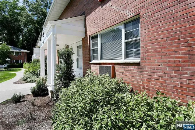 a view of a brick house with a yard and potted plants