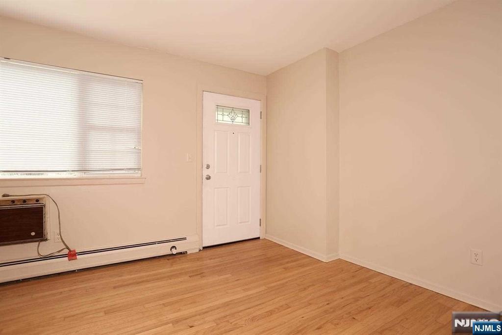 712 Washington Drive, Unit 712 Ramsey, NJ 07446 - Photo 3 of 20 an empty room with wooden floor and windows