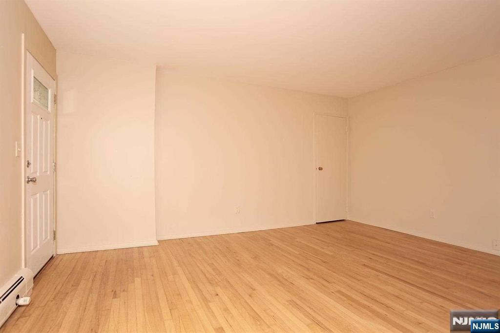 712 Washington Drive, Unit 712 Ramsey, NJ 07446 - Photo 4 of 20 a view of empty room with wooden floor