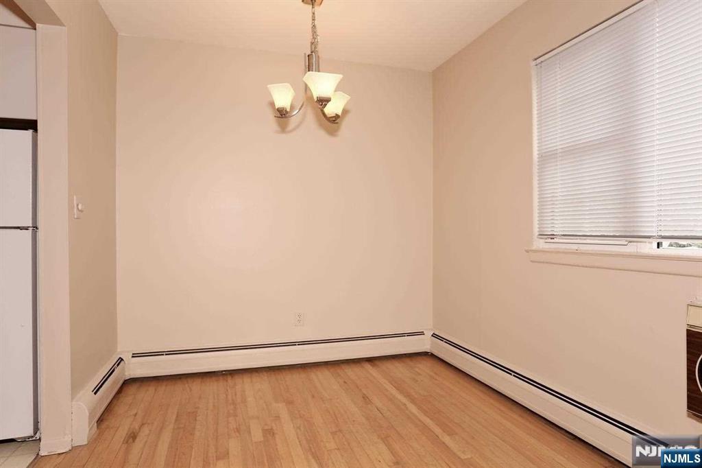 712 Washington Drive, Unit 712 Ramsey, NJ 07446 - Photo 6 of 20 a view of an empty room with wooden floor and a window