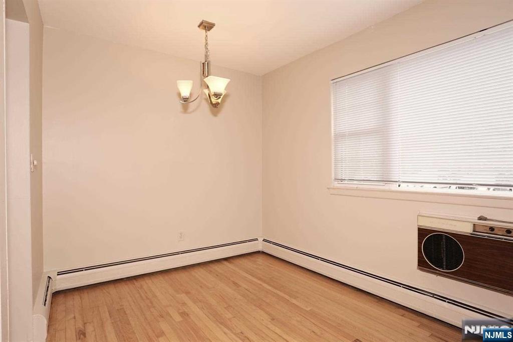 712 Washington Drive, Unit 712 Ramsey, NJ 07446 - Photo 7 of 20 a view of a livingroom with wooden floor a ceiling fan and windows