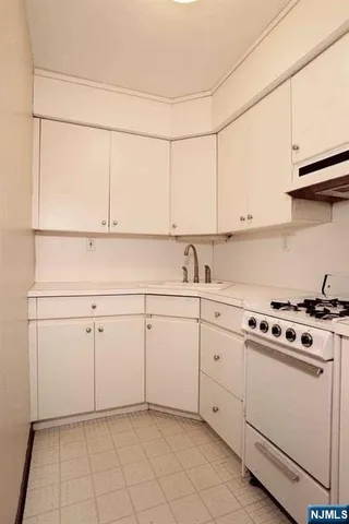 a kitchen with white cabinets and white appliances