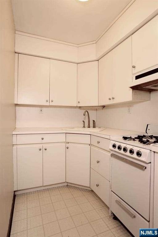 712 Washington Drive, Unit 712 Ramsey, NJ 07446 - Photo 10 of 20 a kitchen with white cabinets and white appliances