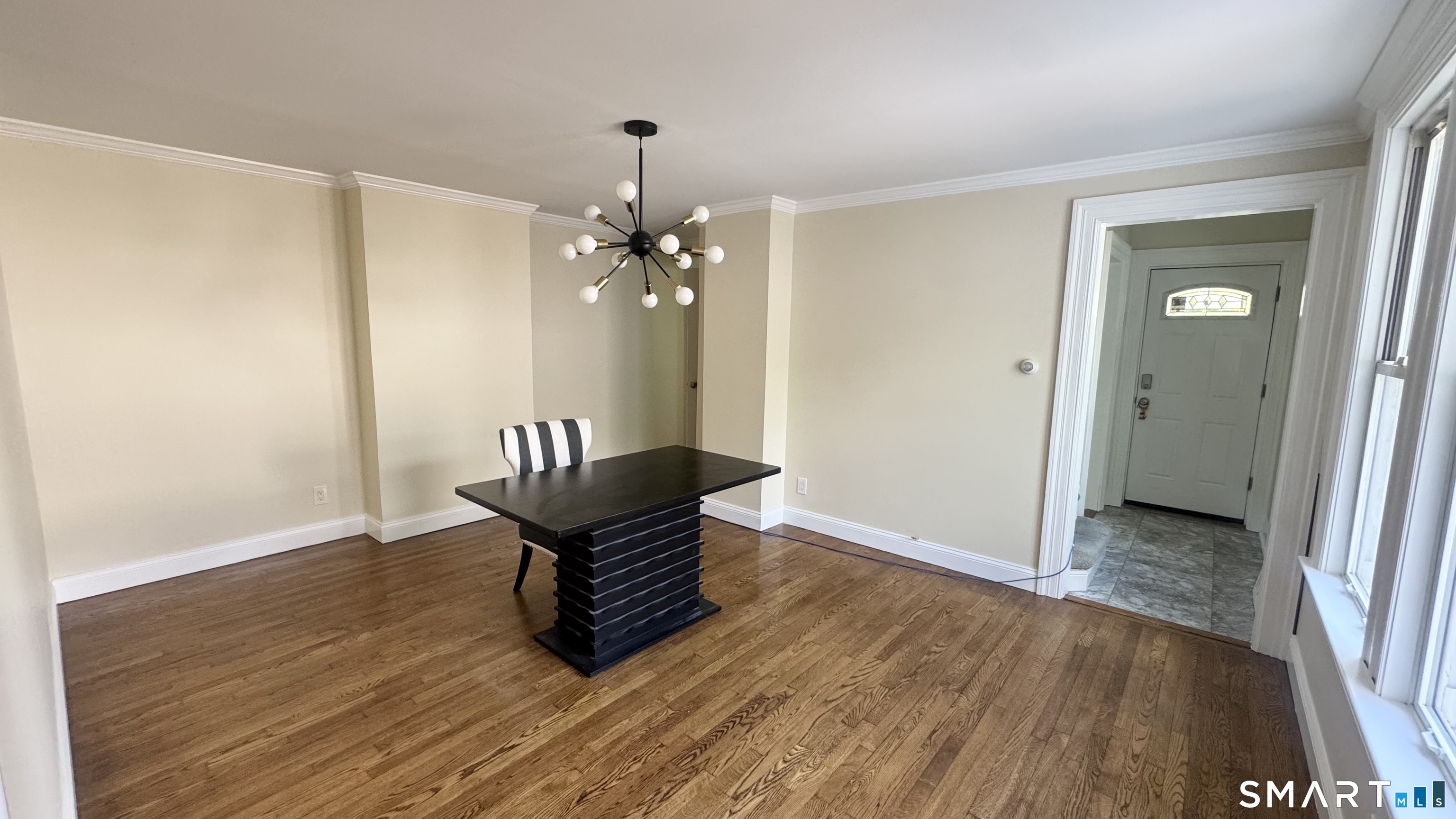 104 Prospect Street Ansonia, CT 06401 - Photo 16 of 40 a view of an empty room with wooden floor and a chandelier