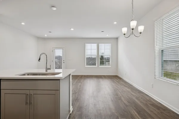 a kitchen with stainless steel appliances granite countertop a sink a stove a refrigerator and a large window