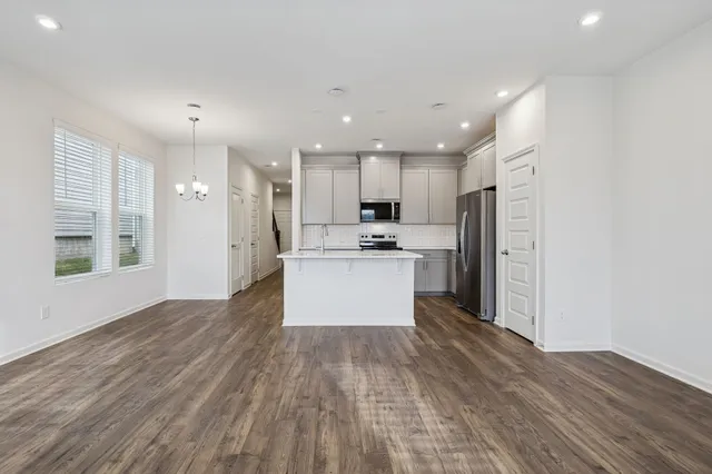 a kitchen with a refrigerator and a stove top oven