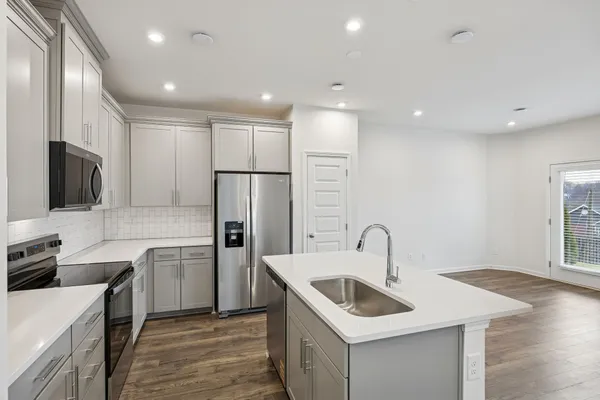 a kitchen with stainless steel appliances a refrigerator sink and microwave
