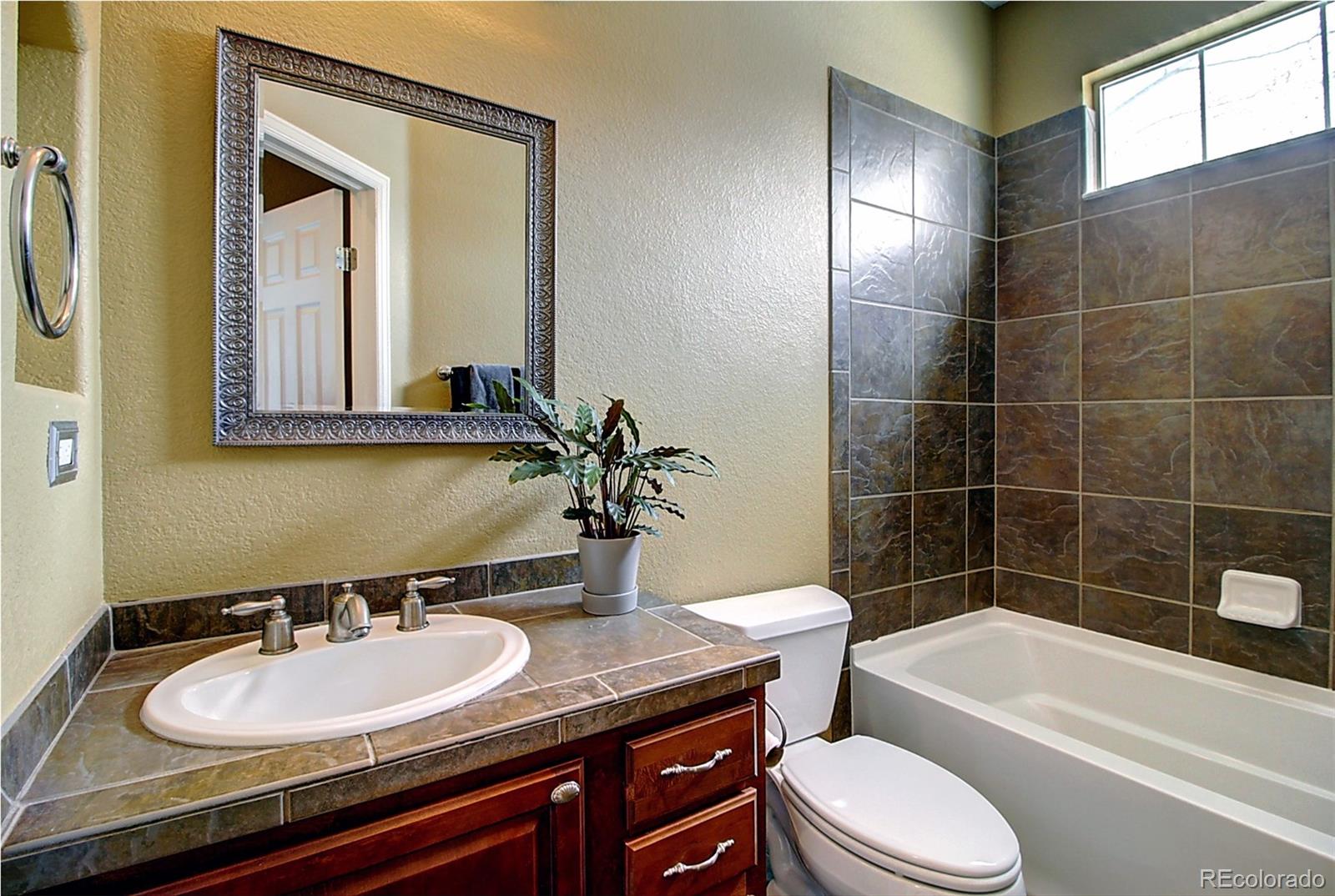 16330 Avalanche Run Broomfield, CO 80023 - Photo 17 of 39 a bathroom with a granite countertop sink toilet and mirror