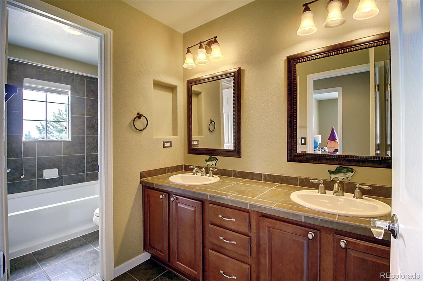 16330 Avalanche Run Broomfield, CO 80023 - Photo 35 of 39 a bathroom with double vanity sinks and a bathtub