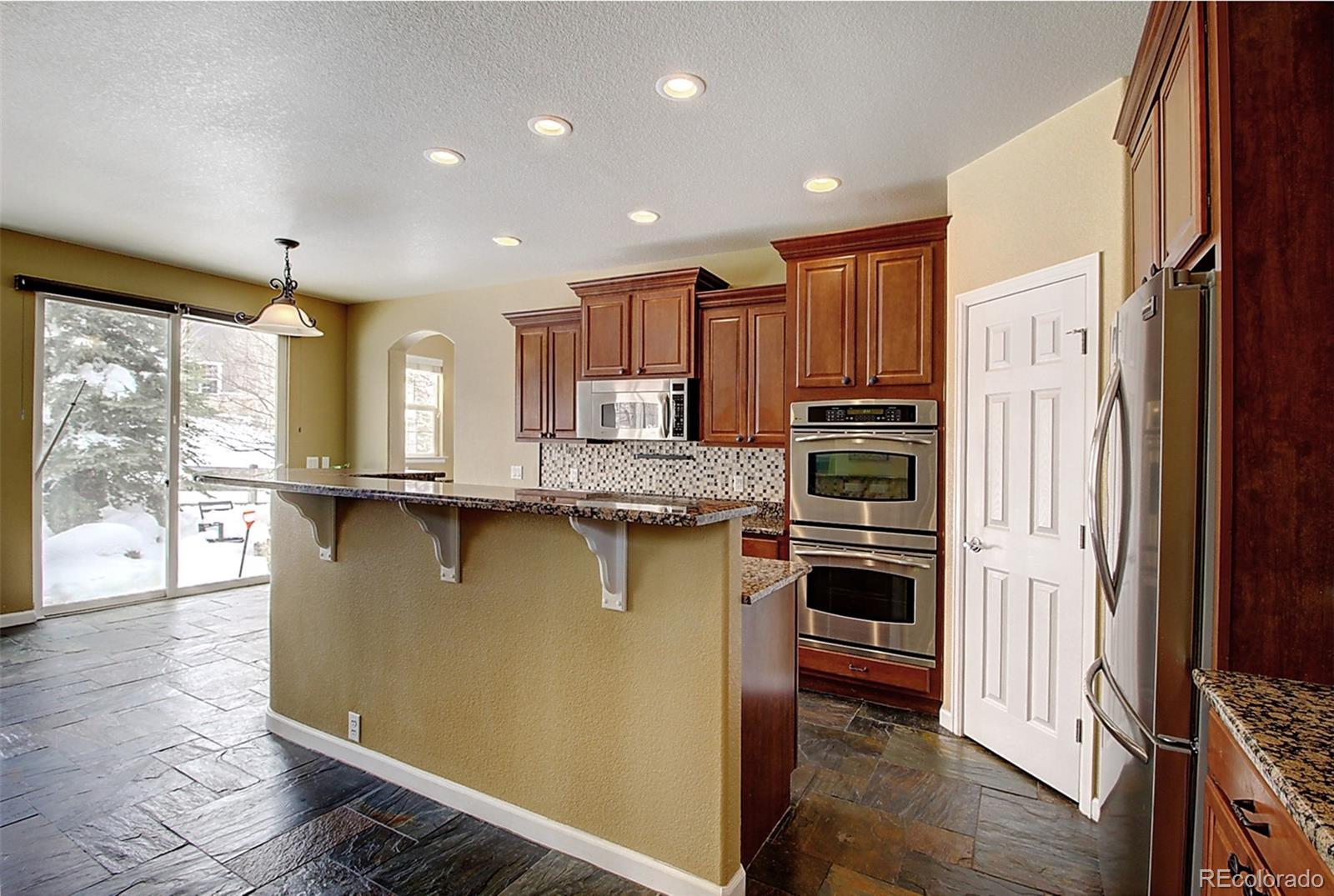 16330 Avalanche Run Broomfield, CO 80023 - Photo 7 of 39 a kitchen with stainless steel appliances granite countertop a refrigerator a stove and a wooden floors