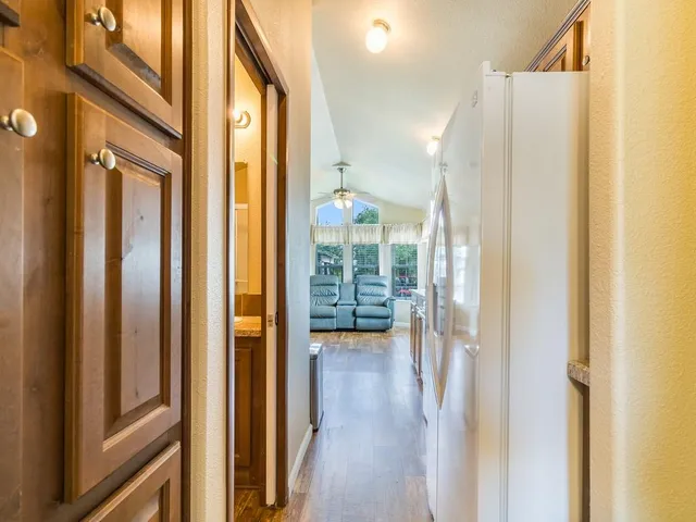 a view of a hallway with wooden floor and staircase