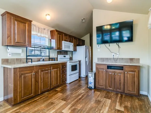 a kitchen with stainless steel appliances a sink cabinets and wooden floor