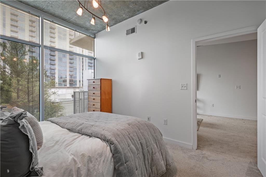 250 Pharr Road Northeast, Unit 606 Atlanta, GA 30305 - Photo 11 of 31 a bedroom with a bed and a large window