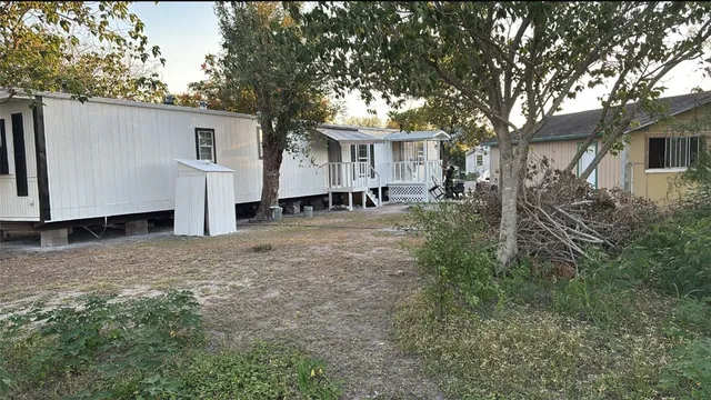 a view of a house with backyard and trees