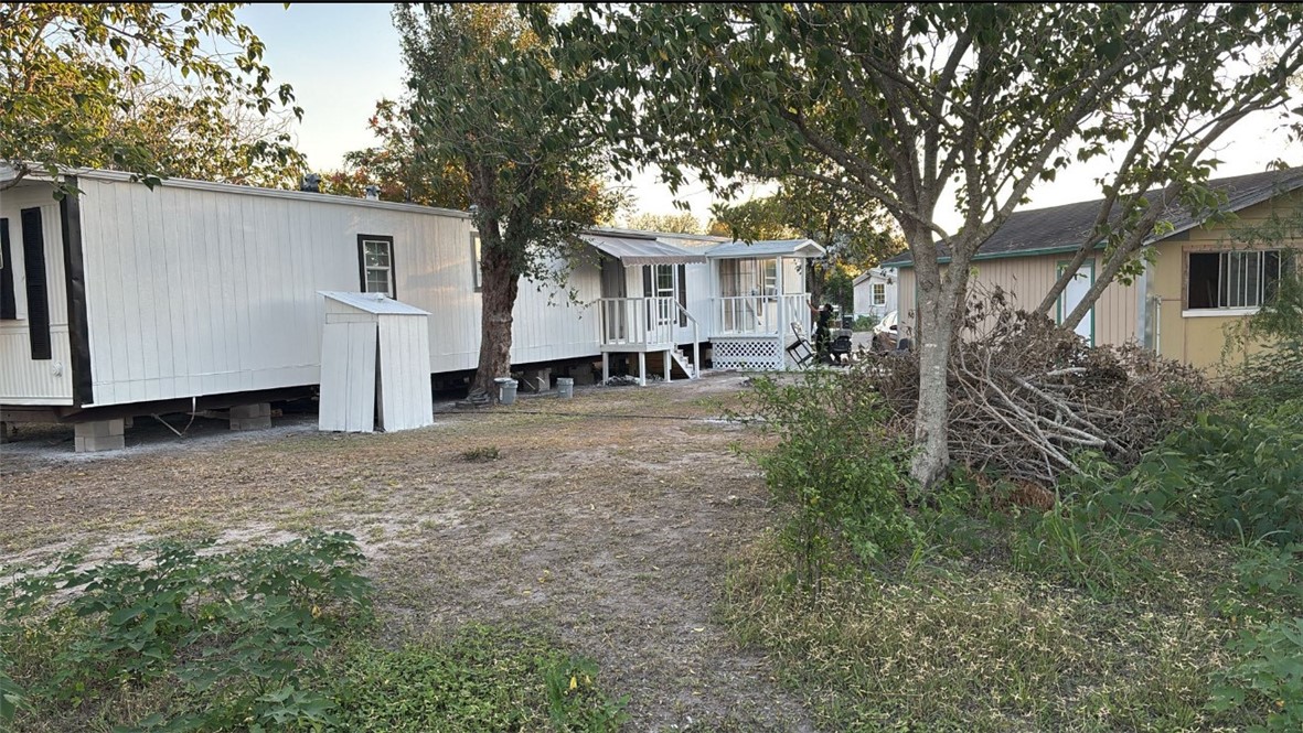 a view of a house with backyard and trees